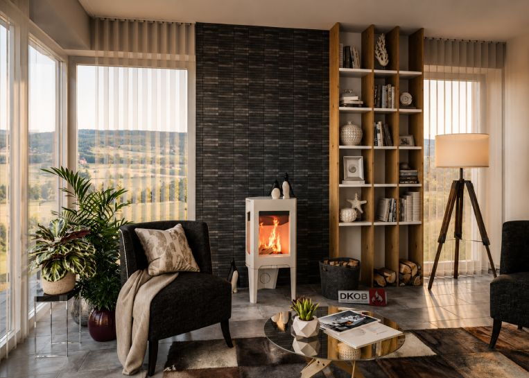 Frontale Ansicht des Ofens im Wohnbereich, die das flache Design und die seitlichen Glasfenster für Rundumsicht auf das Feuer zeigt.
