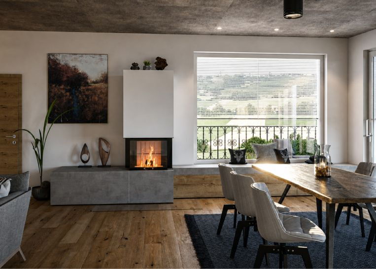 Ein moderner Kamin mit 3-seitiger Sichtscheibe und einer langen, integrierten Sitzbank mit Naturholz-Schubladen vor einem großen Panoramafenster.