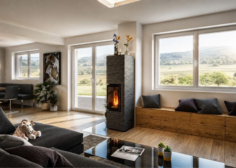 Gesamtansicht des Natursteinofens Rock L1XL mit angrenzender Holz-Sitzbank in einem hellen Wohnzimmer mit weitem Ausblick.