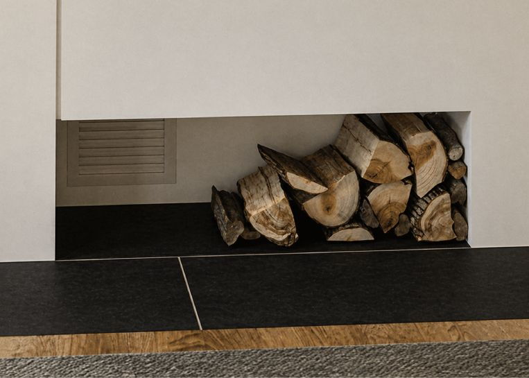 Detailansicht der in den Ofenbau integrierten Holznische über dem flächenbündigen Brandschutz aus hochwertigem Feinsteinzeug.