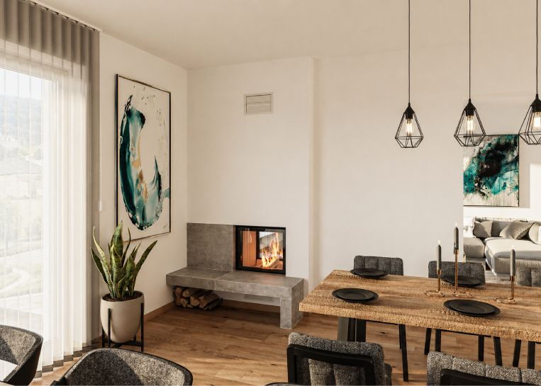 Ein moderner Tunnelkamin mit beidseitiger Sichtscheibe und einem funktionalen Feuertisch aus großformatigem, grauem Feinsteinzeug im Esszimmer.