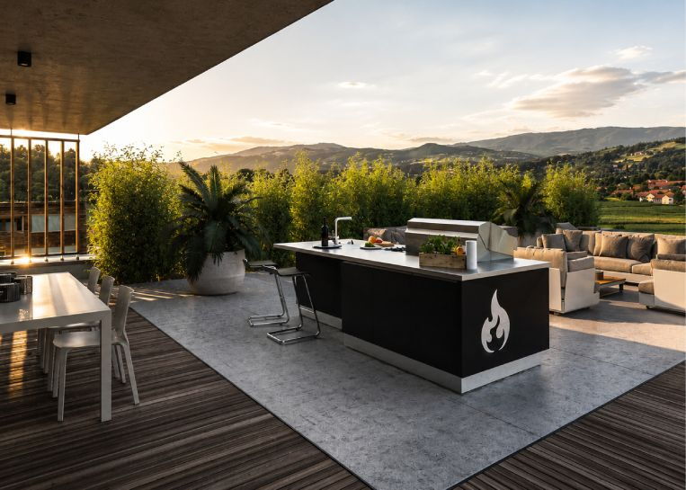 Rückansicht der Kücheninsel mit dekorativem Logo-Ausschnitt, Barstühlen und gemütlicher Outdoor-Lounge.