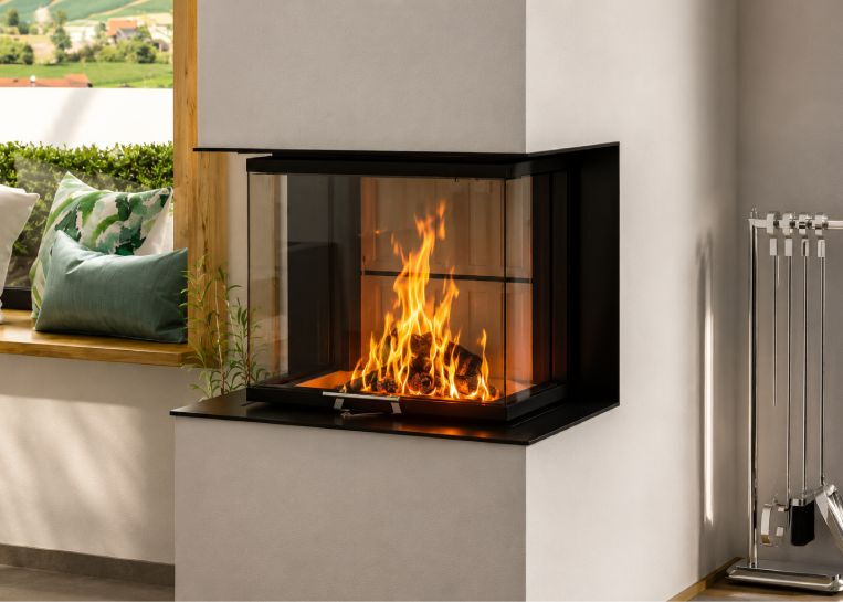 Nahaufnahme der brennenden Holzscheite im Spartherm Kamin, eingefasst in eine schlichte, moderne schwarze Metallblende.