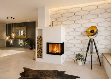 Eine moderne Kaminanlage über Eck mit Spartherm 2R55h Einsatz, integriertem Holzlager und weißem Spachtelputz-Finish.