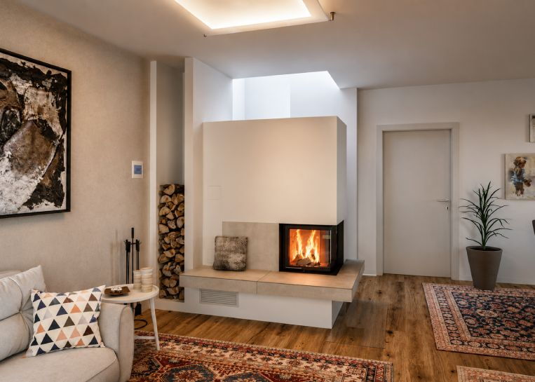 Frontalansicht des Kachelofens mit Brunner HKD 12 Einsatz und einem architektonisch in die Wand integrierten Holzlager.