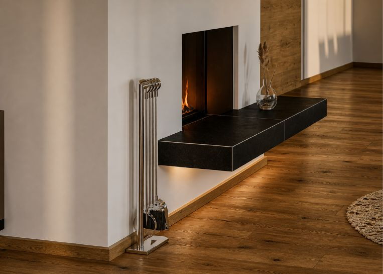 Nahaufnahme des freischwebenden Feuertischs, verkleidet mit großformatigen, schwarzen Keramikplatten und präziser Kantenführung.