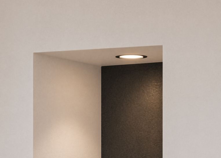 Nahaufnahme des in den Kaminbau integrierten Holzlagers mit dezenter LED-Beleuchtung und Rückwand aus hochwertigem Feinsteinzeug.