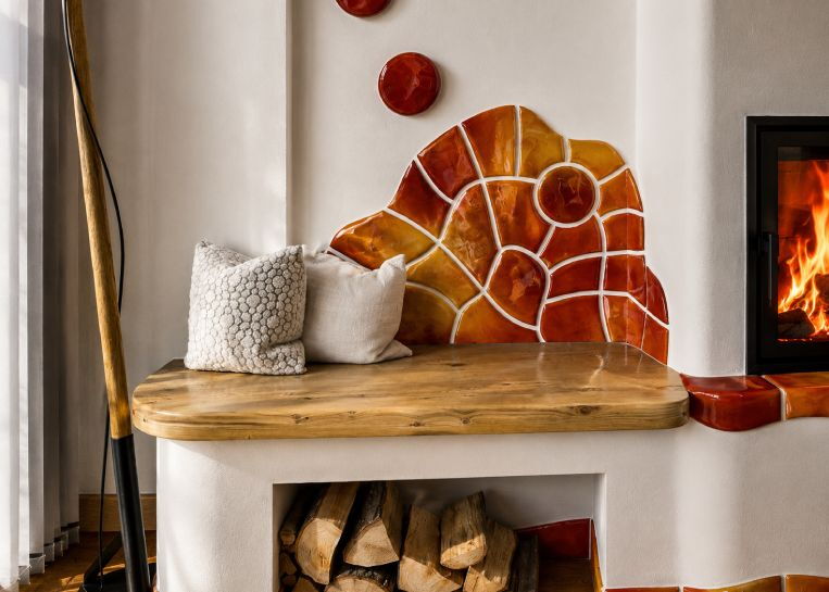 Nahaufnahme der künstlerisch gestalteten Rückenlehne aus Handkeramik-Mosaikstücken hinter der gemütlichen Holz-Sitzbank.