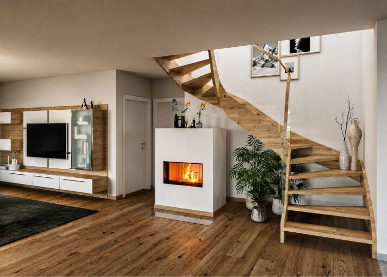 Perspektive auf den schlichten Kamin im Kontext eines modernen Wohnzimmers mit Parkettboden, TV-Wand und dekorativer Treppenkonstruktion.